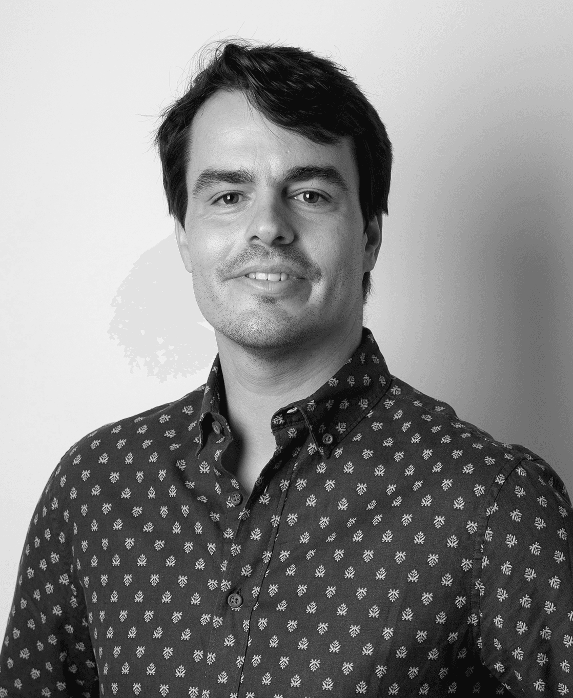Black and white portrait of Joao Garcia, looking directly at the camera with a slight smile