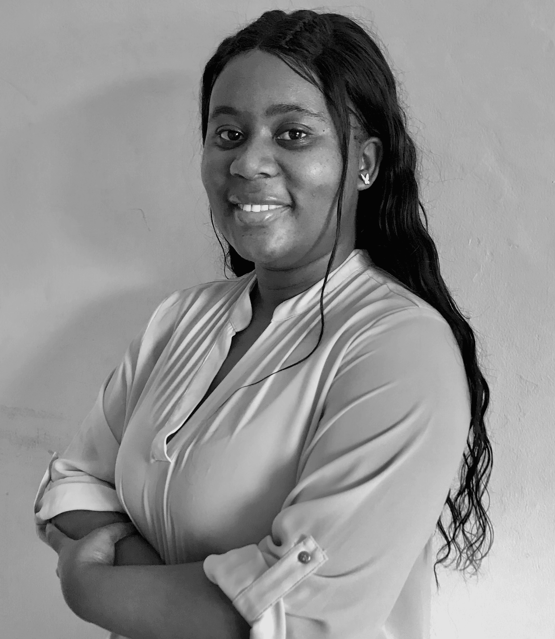 Black and white portrait of Mik Michau, arms crossed, smiling at the camera